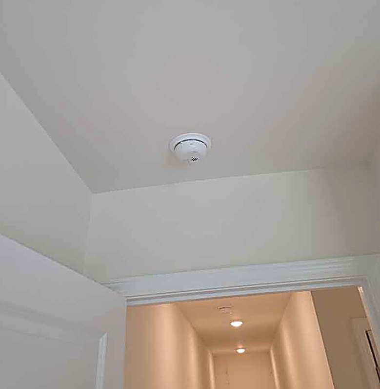 Hardwired smoke detector installed on a ceiling by Fogle & Sons Electric